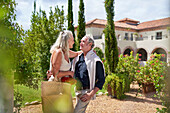 Senior couple hugging in garden outside sunny villa