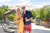 Senior couple drinking cocktails on summer patio