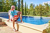 Senior man relaxing by swimming pool