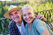 Senior couple taking selfie on balcony