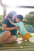 Mother and son at sunny playground structure
