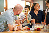 Boy with Down syndrome baking with family in kitchen