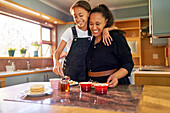 Mother and daughter eating pancakes in kitchen