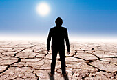 Man standing on cracked earth, composite conceptual image