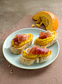 Crostini with pumpkin cream and Serrano ham