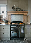 Kitchen unit with antique stove, tiled backsplash and floor tiles