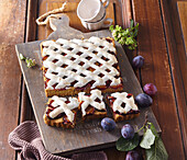Plum cake from the tray with meringue lattice