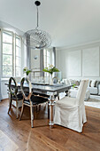Dining area with chrome table, silver chairs and pendant light in modern design
