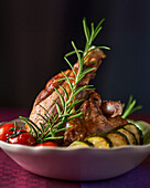 Roasted leg of lamb with rosemary, courgettes and tomatoes
