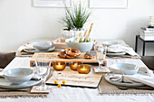 Dining table setting with personalised wooden boards, golden tea light holders and pretzels