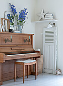 Old piano with stool and flower vase as decoration