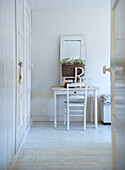 Dressing table with chair and mirror in white room