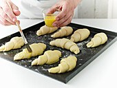 Brush croissants with butter before baking