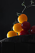 Gelbe und rote Kirschtomaten vor schwarzem Hintergrund