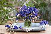 Bouquet of rock pear (Amelanchier), grape hyacinth (Muscari) and hyacinth (Hyacinthus) on patio table