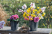 Blumenstrauss aus Narzissen 'Tete a Tete', Echte Mandelblüten, Hyazinthen, Primeln in Vase auf Holzbank