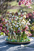 Small bouquets of grape hyacinth 'Mountain Lady', spring knotweed 'Gravetye Giant' and pussy willow on patio table