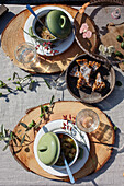 Placemat made from rustic wooden discs, with green soup bowls with lids