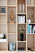 Wooden shelf with decorative objects, books and candlesticks