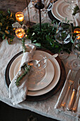 Festively laid table with linen napkins, candles and eucalyptus branches