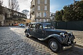 France,Paris,Montmartre,Citroën Traction Avant car on a paved street and in the background of the 2 CV Citröen