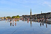France,Gironde,Bordeaux,area listed as World Heritage by UNESCO,Saint Pierre district,Place de la Bourse,the reflecting pool from 2006 and directed by Jean-Max Llorca hydrant and Saint Michel basilica in the background