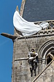 France,Manche,Cotentin,Sainte Mere Eglise,one of the first communes of France liberated on June 6,1944,model of American paratrooper John Steele (1912-1969) from the 505th Parachute Infantry Regiment who landed on the bell tower of the church