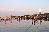 France,Gironde,Bordeaux,area listed as World Heritage by UNESCO,Saint Pierre district,Place de la Bourse,the reflecting pool from 2006 and directed by Jean-Max Llorca hydrant and Saint Michel basilica in the background