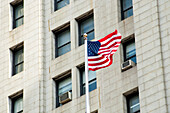 American Flag Waving In Front Of A Building Facade,Manhattan,New York,Usa