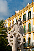 Spain,Ibiza,Statue of sailor at helm in front of old residential building,Ibiza Town