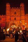 England,People with burning torches going through archway to Battle Abbeyt,East Sussex