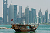 Qatar,Wooden boat in front of modern city skyline,Doha
