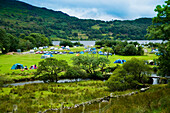 Nordwales. UK,Snowdonia National Park,Nantgwynant,Fluss und See,Llyn Gwynant Campsite,umgeben von Hügeln,Bunte Zelte & Wohnwagen im Tal