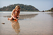 Savanna Rollason sammelt Muscheln am Strand von Palolem, Goa, Indien.