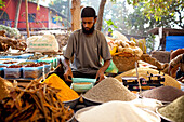 A vendor sits amongst his dried produce in Chaudi Market,Chaudi,Goa,India.