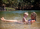 Mum and daughter enjoy swiming in the shallow fresh waters of the lagoon on Cola beach,Goa,India.