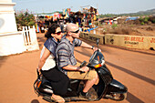 Touristen auf Motorrollern auf dem Weg zum weltberühmten Anjuna Flea Market, der mittwochs am Anjuna Beach im Bundesstaat Goa, Indien, Asien, stattfindet.