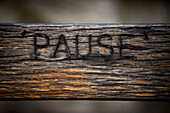 UK,London,Detail of word pause carved in wooden bench in Richmond Hill,Richmond