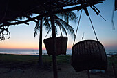 Myanmar (Burma),Irrawaddyi division,Fish panniers in bamboo hut on seashore at sunset,Yea Thoe village