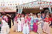 Gruppe junger Frauen in traditionellen Kleidern während des Feria-Festivals im April, Sevilla, Andalusien, Spanien