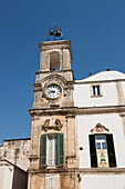 Traditionelle apulische Architektur mit alter Uhr und grünen hölzernen Fensterläden, Martina Franca, Apulien, Italien
