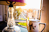 Teekanne und Lampe auf der Fensterbank in der Nachmittagssonne, Baron's Court, West London, England