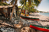 Fishing huts and traditional dugout fishing boats beached along the shore of the village of Scotts Head in Soufriere Bay on the Island of Dominica,Soufriere,Dominica,Caribbean
