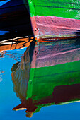Detail eines kleinen, hölzernen Fischerboots, das am Ufer vertäut ist, mit einer Spiegelung im ruhigen Wasser in der Küstenstadt Getaria,Getaria,Gipuzkoa,Spanien