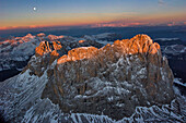 Luftaufnahme der Dolomiten bei Sonnenaufgang und sichtbarem Mond, St. Ulrich, Italien