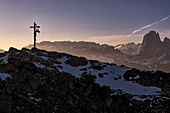 Ein Kruzifix steht auf einem Gipfel in den italienischen Dolomiten, St. Ulrich, Italien