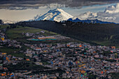 Der Vulkan Cotopaxi erhebt sich über der Stadt Quito in den Bergen, Quito, Ecuador