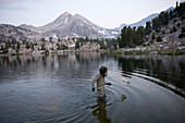 Mann benutzt ein Netz zum Fischfang im Sixty Lake Basin, Kings Canyon National Park, Kalifornien, USA, Kalifornien, Vereinigte Staaten von Amerika