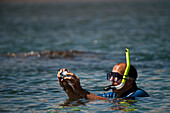 Tourist photographs the scenery around him while snorkeling in Galapagos Islands National Park,Galapagos Islands,Ecuador