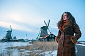 Junge Frau posiert in der Zaanse Schans, einem historischen Windmühlenviertel in den Niederlanden, Amsterdam, Niederlande